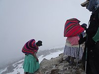 Små damer i skjørt går forbi oss med tunge bører på vei til high camp